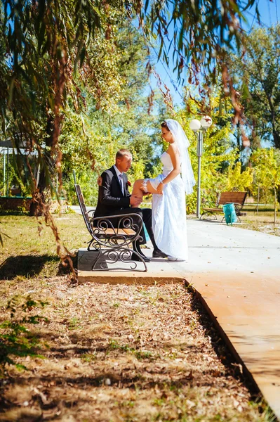 Noiva e noivo no dia do casamento andando ao ar livre na natureza de primavera. Casal nupcial, mulher recém-casada feliz e homem abraçando no parque verde. Casal de amor ao ar livre . — Fotografia de Stock