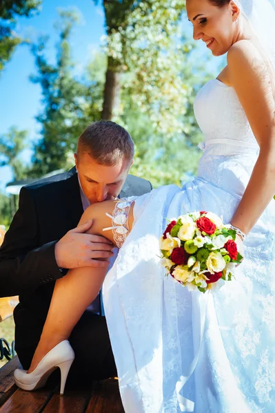 Novia y novio en el día de la boda caminando al aire libre en la naturaleza de primavera. Pareja nupcial, feliz mujer recién casada y hombre abrazándose en el parque verde. Amar pareja de boda al aire libre . —  Fotos de Stock