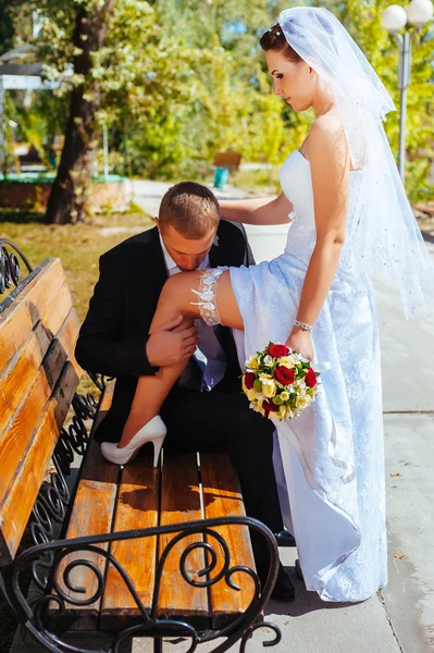 Novia y novio en el día de la boda caminando al aire libre en la naturaleza de primavera. Pareja nupcial, feliz mujer recién casada y hombre abrazándose en el parque verde. Amar pareja de boda al aire libre . — Foto de Stock