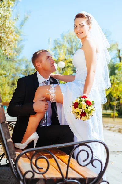 Novia y novio en el día de la boda caminando al aire libre en la naturaleza de primavera. Pareja nupcial, feliz mujer recién casada y hombre abrazándose en el parque verde. Amar pareja de boda al aire libre . —  Fotos de Stock