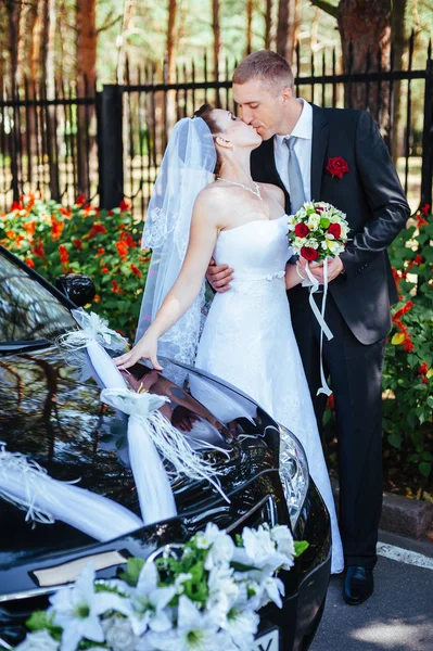 Caucasian Bride and groom near vintage wedding car. — Stock Photo, Image