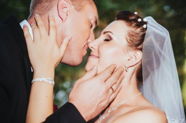 Deniz kenarında bir düğün. Balayı. Gelin ve damat Gölü kıyısına sarılma. damat ve gelin yeşil bir gölde sarılma. Damat ve gelin bir parkta. gelinlik. Gelin düğün buket çiçek.