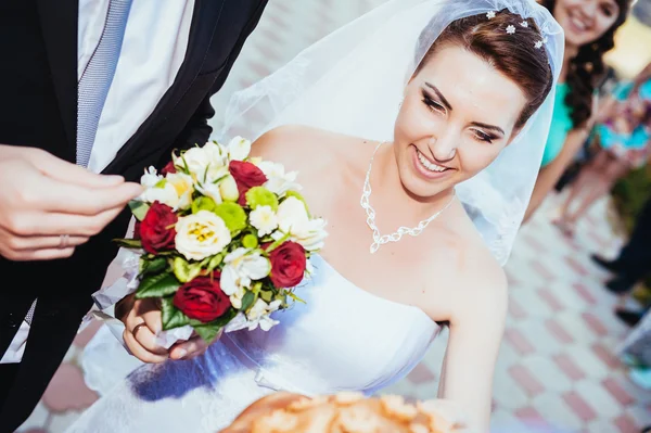 Um casamento à beira-mar. Lua-de-mel. A noiva e o noivo abraçados na margem do lago. noivo e noiva abraçando em um lago verde. O noivo e a noiva num parque. Vestido de noiva. Buquê de casamento nupcial de flores . — Fotografia de Stock