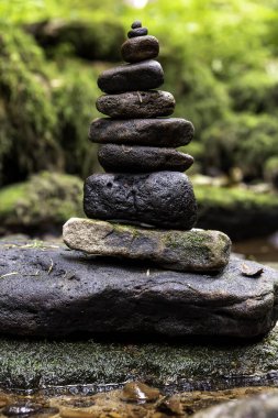 Yumuşak taşlardan oluşan narin bir kule daha büyük bir taşın üzerinde düzgünce düzenlenir. Etrafı sakin bir akarsu ve ormandaki canlı yeşilliklerle çevrilidir..