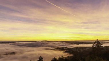 Bad Salzig, Almanya yakınlarındaki Rhine Nehri 'nde nefes kesen gün doğumuna tanık olun. Bulutlar vadiyi canlı renklerle kaplıyor, gökyüzünü aydınlatıyor, dingin bir sabah atmosferi yaratıyor..