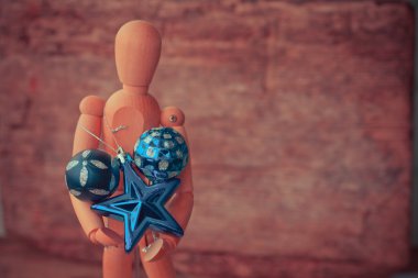 Ahşap ahşap arka plan üzerinde parlak Noel baubles ile adam figürü 