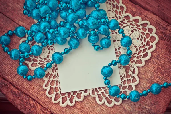 Blaue Perlenkette Für Weihnachtsbaum Und Weiße Papierkarte Auf Holzgrund — Stockfoto