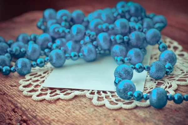 Blue beaded necklace and paper card — Stock Photo, Image