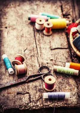 eski makas ve bobin iplik ve eski ahşap zemin üzerine iğne ile