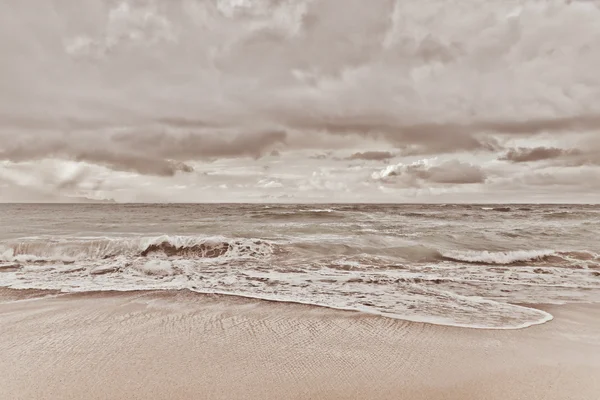 ocean with calm water and white fluffy clouds on sky