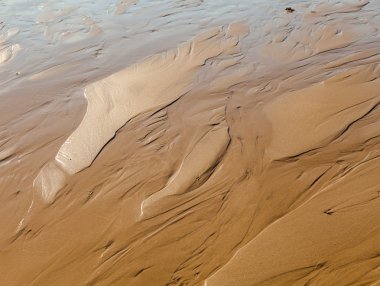 güneşli bir gün ıslak kumsalda yüzeyi sakinleştirmek kum dalgaları