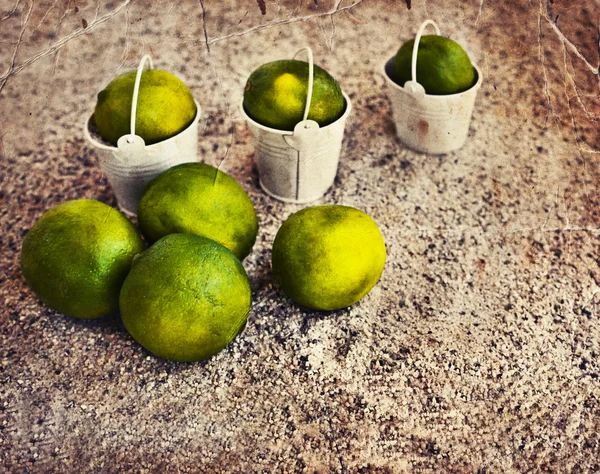 Little white buckets with limes — Stock Photo, Image