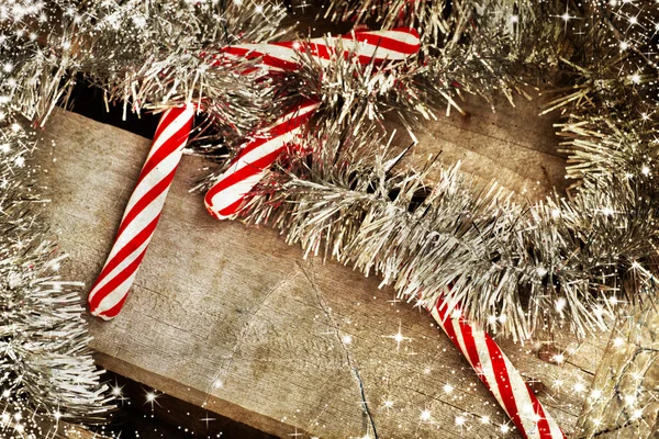 Candy canes wit holiday tinsel — Stock Photo, Image
