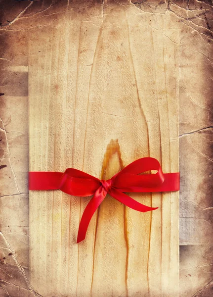 Arco rosso su regalo di legno — Foto Stock