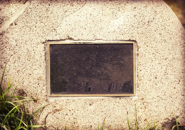 Weathered plaque in wall stone — Stock Photo, Image