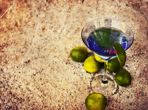 Cocktail glass with straw and lime — Stock Photo, Image