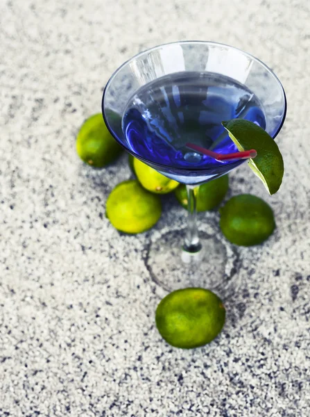 Cocktail glass with straw and limes — Stock Photo, Image