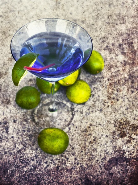 Cocktail glass with straw and limes — Stock Photo, Image