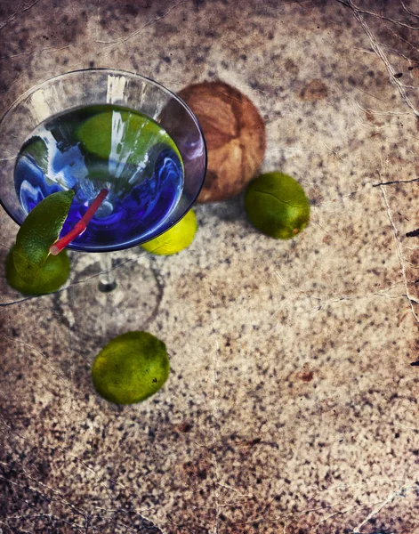 Cocktail glass with straw and limes — Stock Photo, Image