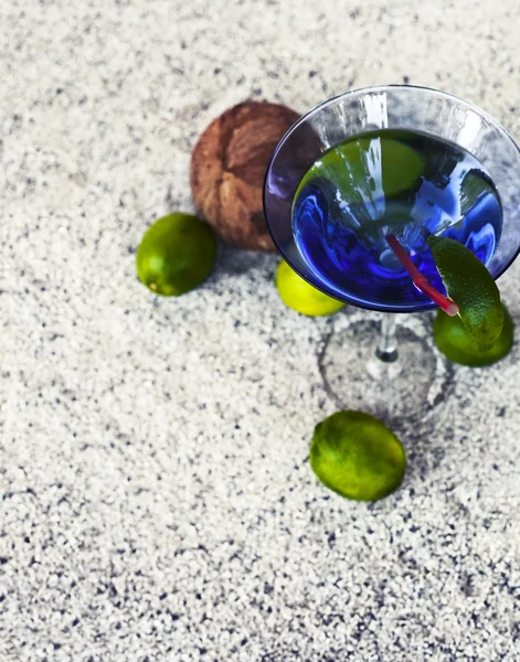 Cocktail glass with straw and limes — Stock Photo, Image