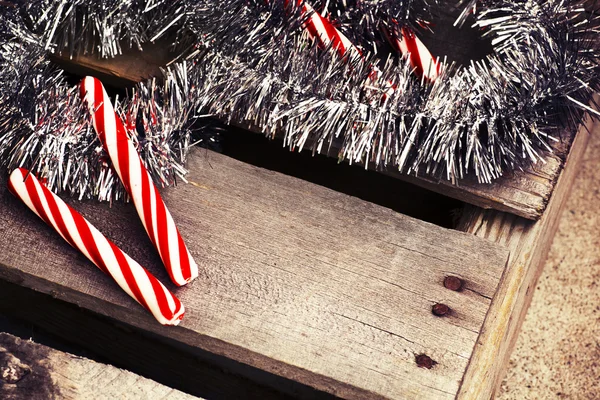 Candy canes wit holiday tinsel — Stock Photo, Image