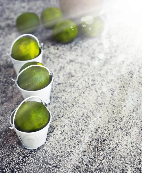 White buckets with limes — Stock Photo, Image