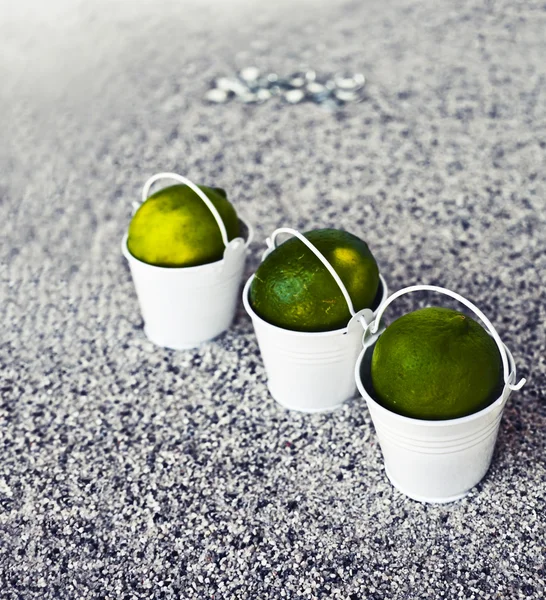 White buckets with limes — Stock Photo, Image