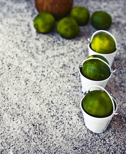 White buckets with limes — Stock Photo, Image