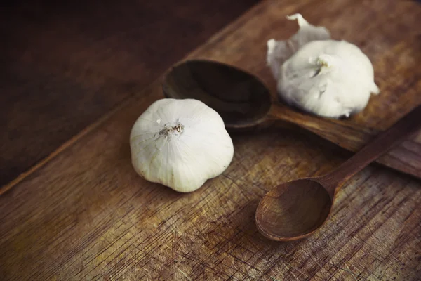 Garlic and wooden spoons — Stock Photo, Image