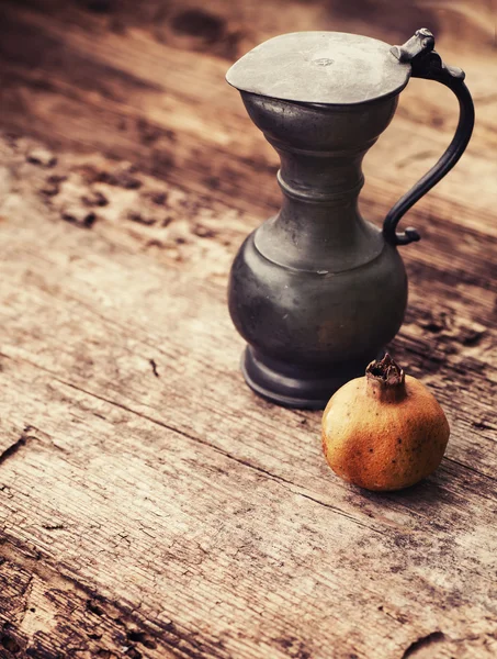 Copper jug with pomegranate — Stock Photo, Image