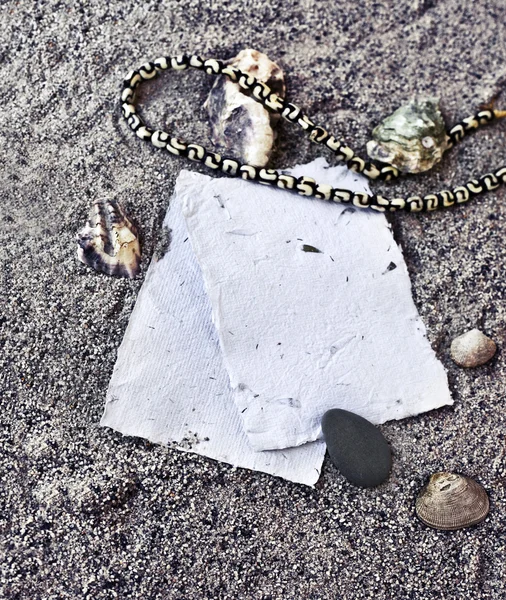 Arrière-plan avec sable, pile de papiers blancs, coquillages et pierres — Photo