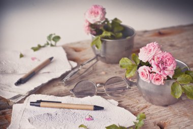 Ahşap masa gözlüklerle pembe güller