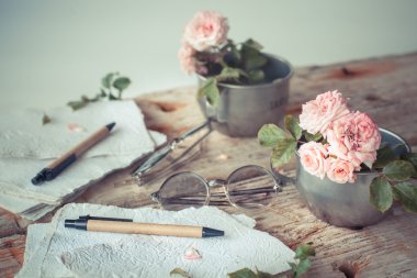 Ahşap masa gözlüklerle pembe güller