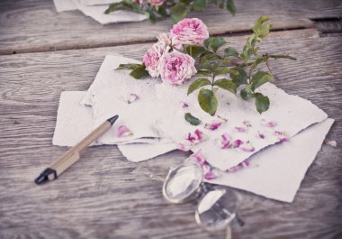 Ahşap masa gözlüklerle pembe güller