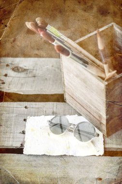Boya fırçaları, gözlük ve kağıt