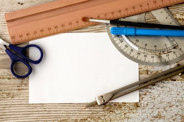 Beyaz kağıt, fırça, cetveller, bölücü, makas ve mavi marker