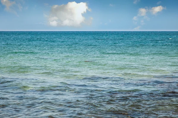 Zee en pluizige wolken — Stockfoto