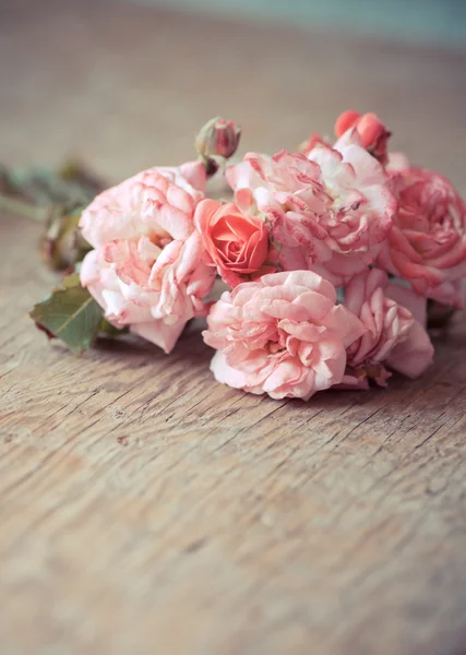 Rosas cor-de-rosa na mesa de madeira — Fotografia de Stock