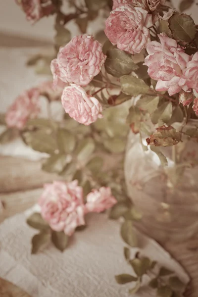 Rosas cor de rosa com papéis na mesa de madeira — Fotografia de Stock