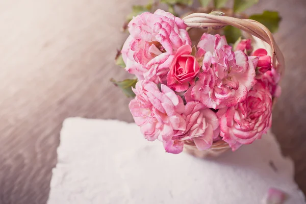 Rosas rosadas con papeles sobre mesa de madera —  Fotos de Stock