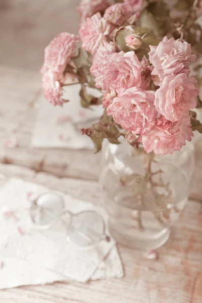 Rosas rosadas con gafas sobre mesa de madera —  Fotos de Stock