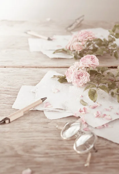 Roses roses avec verres sur table en bois — Photo