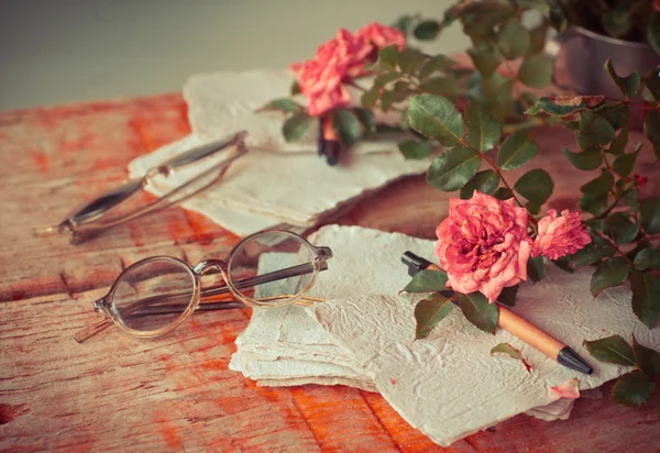 Roses roses avec verres sur table en bois — Photo