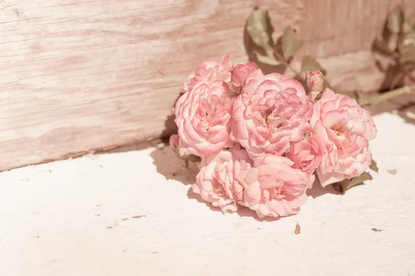 Rosas rosadas sobre mesa de madera — Foto de Stock