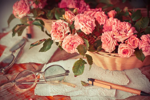 Rosas rosadas con gafas sobre mesa de madera —  Fotos de Stock