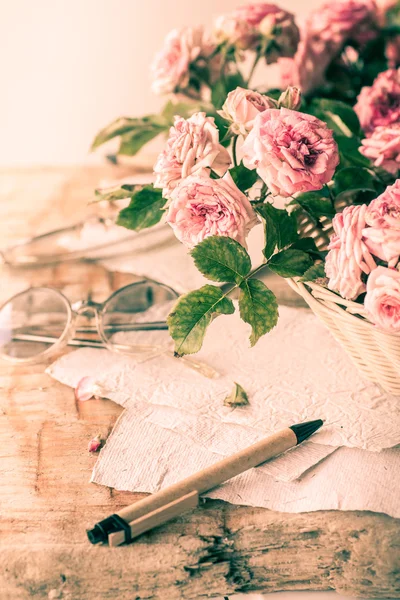 Rosas rosadas con gafas sobre mesa de madera —  Fotos de Stock