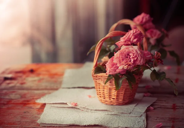 나무 테이블에 서류와 함께 핑크 장미 — 스톡 사진