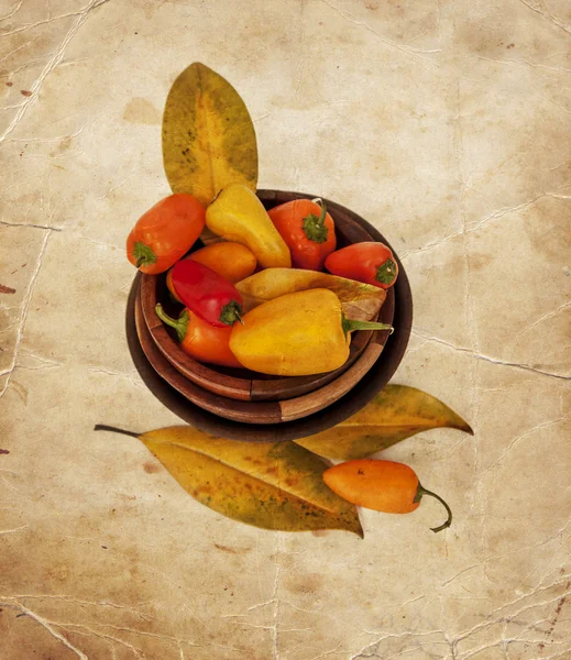 Peppers in bowls, yellow autumn leaves — Stock Photo, Image