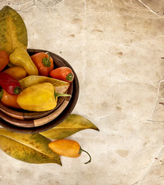 Peppers in bowls, yellow autumn leaves — Stock Photo, Image