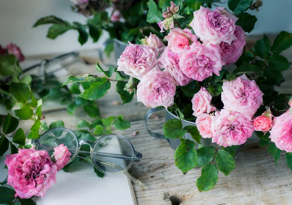 Rosas rosadas con gafas sobre mesa de madera —  Fotos de Stock